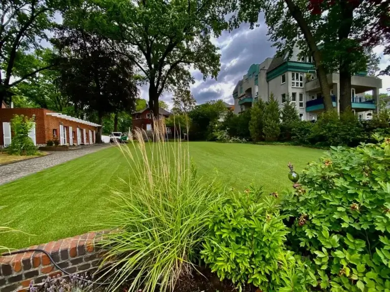 Kunstrasenfläche in einer Gartenanlage mit Gräsern und Stauden – TOP GREEN Referenz