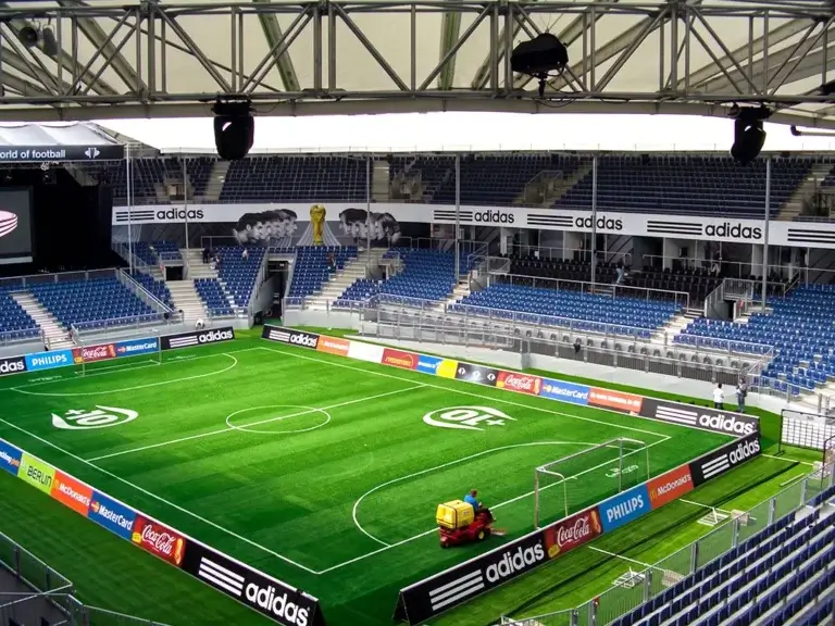 Fußballstadion mit Spielfeld und Tribünen – TOP GREEN Referenz Sportanlagen