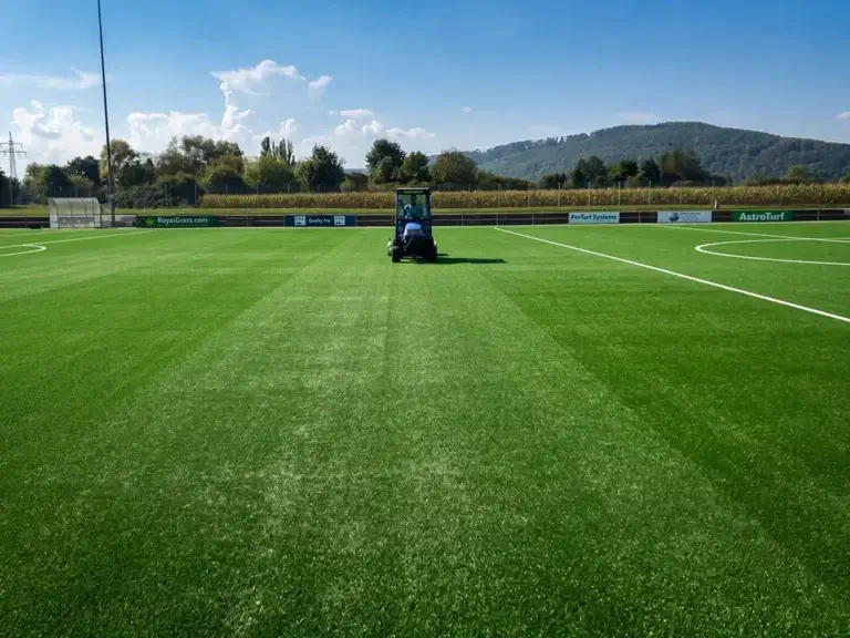 Großes Rasenspielfeld mit Pflegemaschine – TOP GREEN Referenz